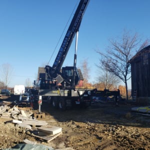 Crane positioned on construction site with surrounding debris, showcasing KraneWorks' crane services for project installations.