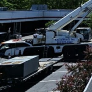 Kraneworks crane truck in action, lifting materials on a construction site, showcasing professional crane services for residential and commercial projects.