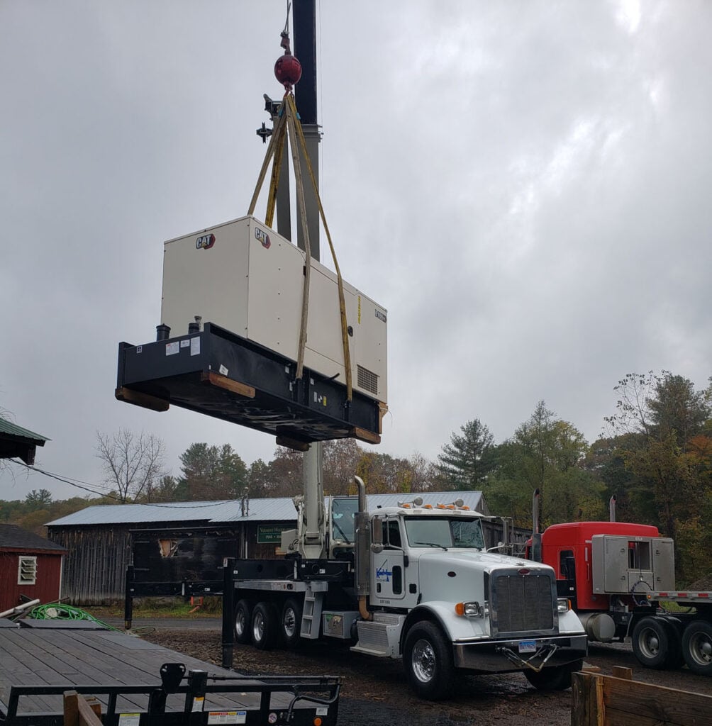 Crane lifting HVAC unit onto truck for rooftop installation support by Kraneworks, showcasing professional equipment and services for HVAC technicians.